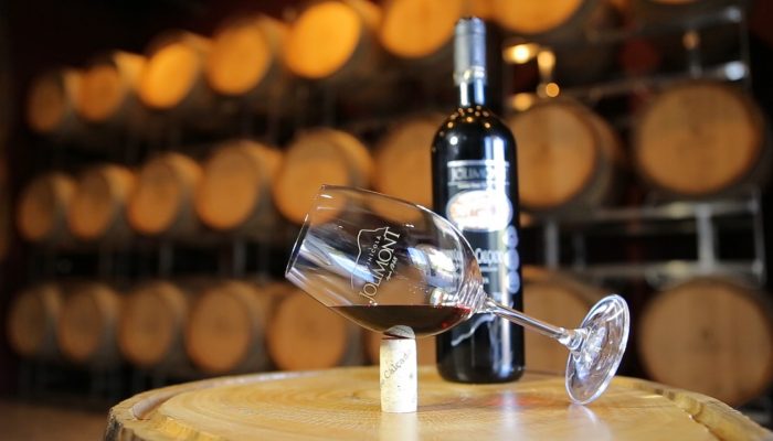 Taça e garrafa de vinho Jolimont sobre barril na cave da vinícola em Canela